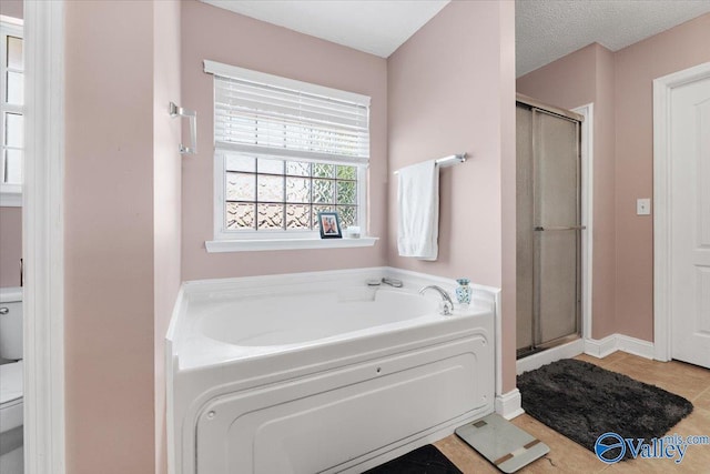 bathroom with a garden tub, tile patterned floors, toilet, and a shower stall
