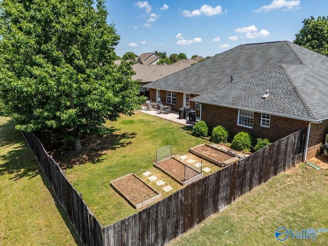 view of yard with a fenced backyard, a patio, and a vegetable garden