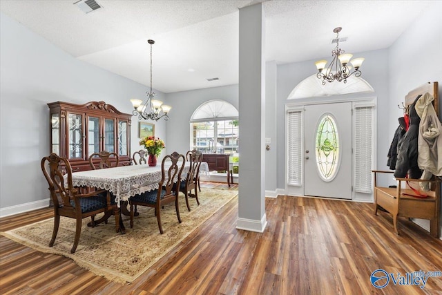 entryway with baseboards, an inviting chandelier, wood finished floors, and visible vents