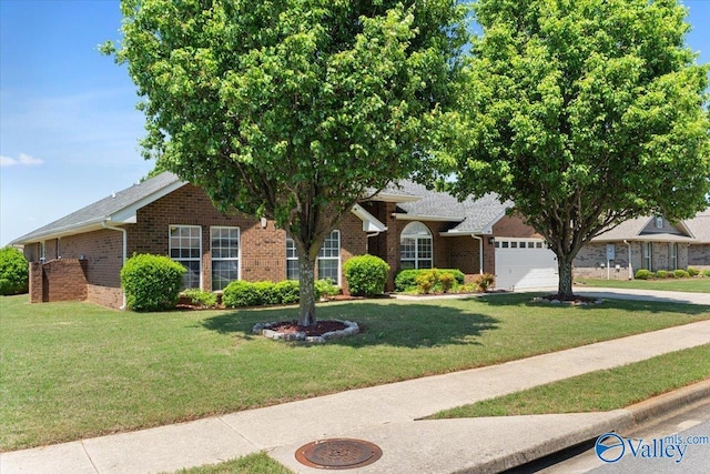 view of front facade with brick siding, an attached garage, and a front yard