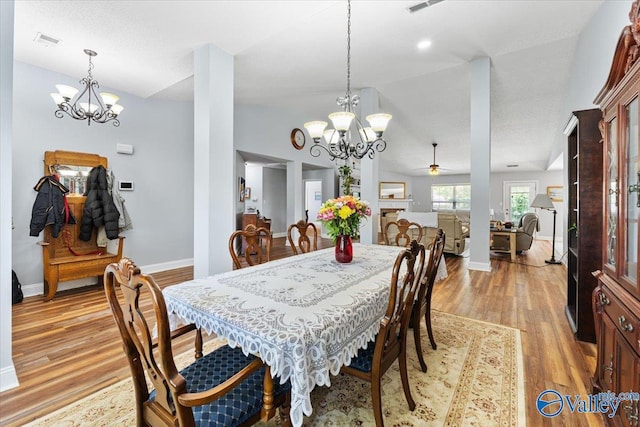 dining area with baseboards, visible vents, light wood-style flooring, and ceiling fan with notable chandelier