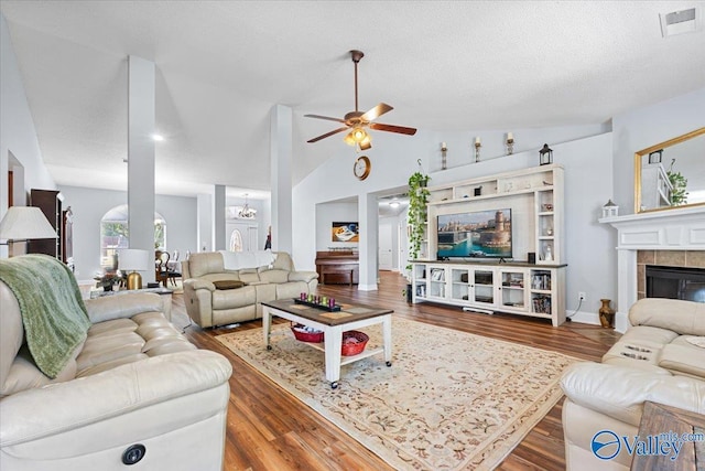 living area featuring visible vents, wood finished floors, and ceiling fan with notable chandelier