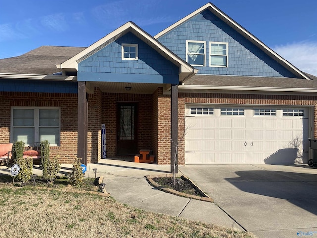 view of front facade featuring driveway, a porch, a shingled roof, a garage, and brick siding