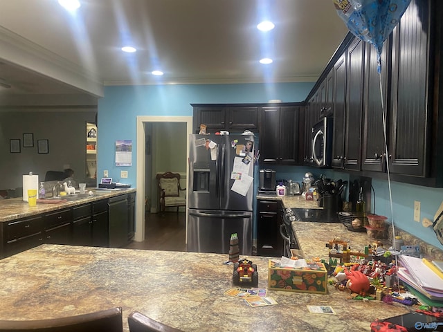 kitchen featuring a sink, recessed lighting, appliances with stainless steel finishes, crown molding, and dark cabinets