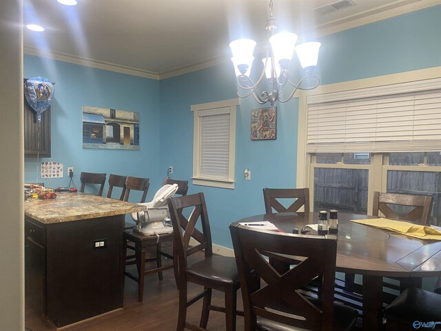 dining space featuring visible vents, baseboards, ornamental molding, an inviting chandelier, and wood finished floors