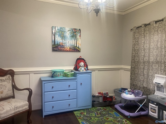 game room with an inviting chandelier, a wainscoted wall, and dark wood-type flooring