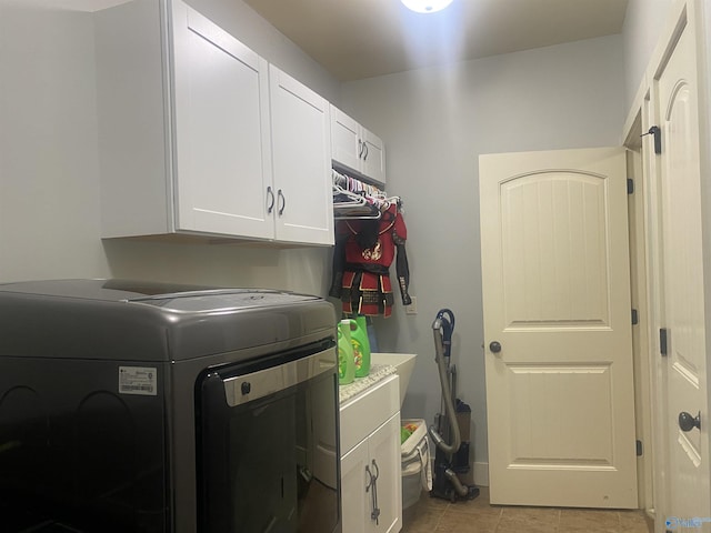 laundry room with light tile patterned floors, cabinet space, and washer / dryer