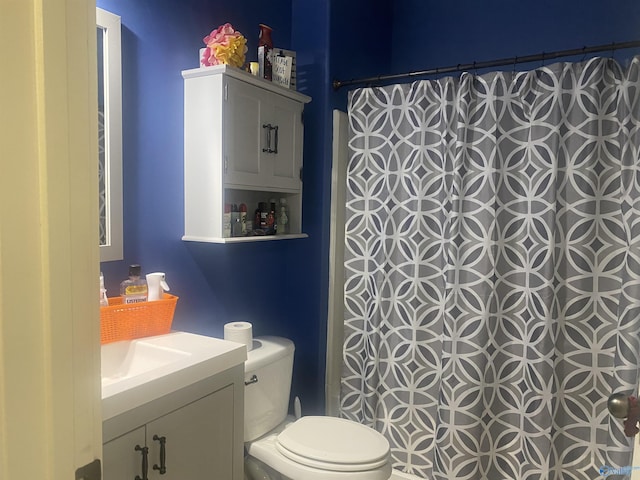 bathroom with toilet, curtained shower, and vanity