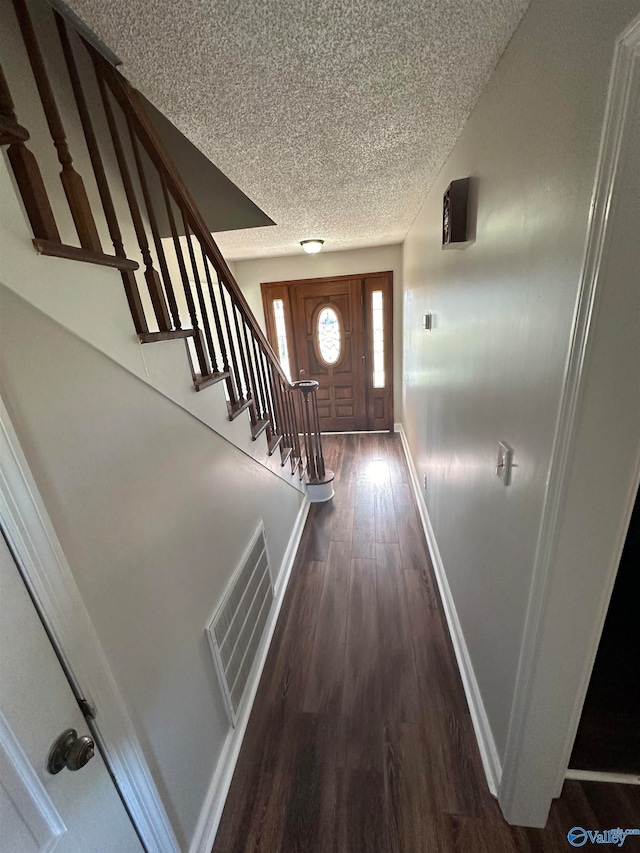 entrance foyer featuring dark wood-type flooring and a textured ceiling