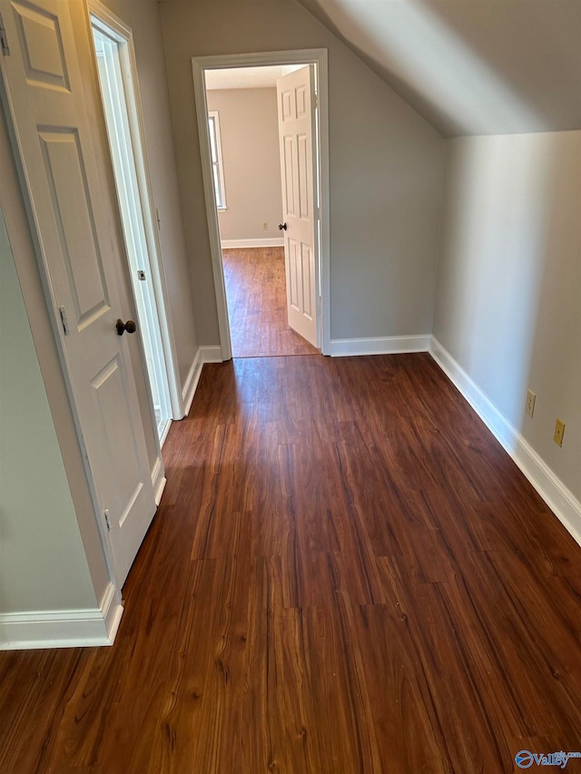 additional living space featuring dark hardwood / wood-style floors and vaulted ceiling