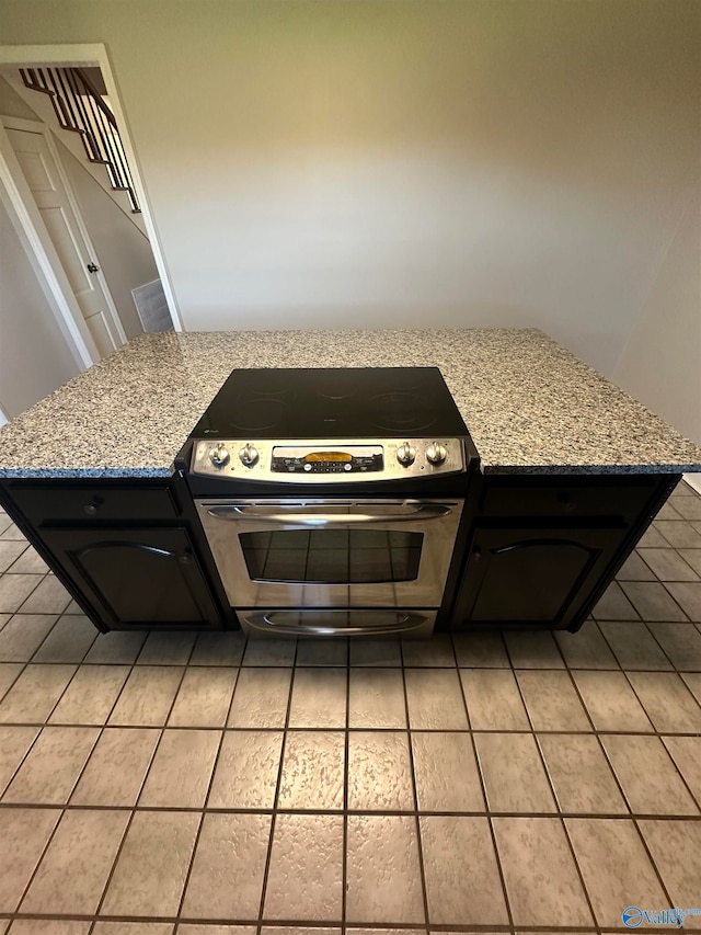 kitchen with light stone counters and range with two ovens