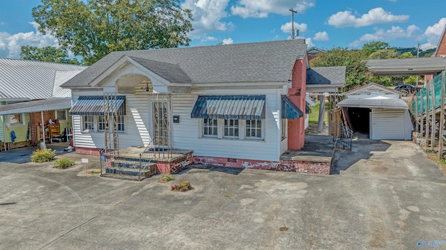 view of front of house featuring a garage and an outbuilding