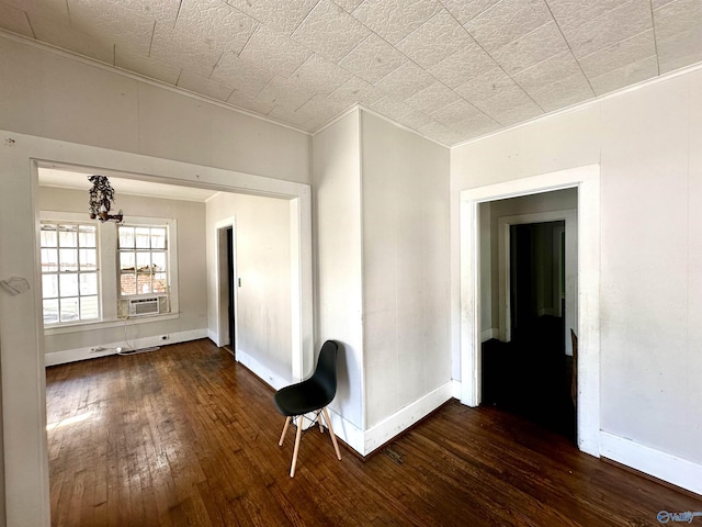 empty room featuring ornamental molding, dark hardwood / wood-style flooring, cooling unit, and a chandelier