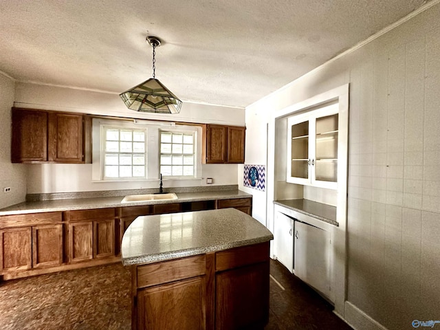 kitchen with sink, a textured ceiling, and hanging light fixtures