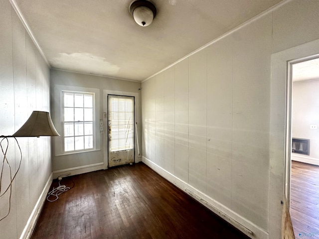 doorway with dark wood-type flooring and ornamental molding