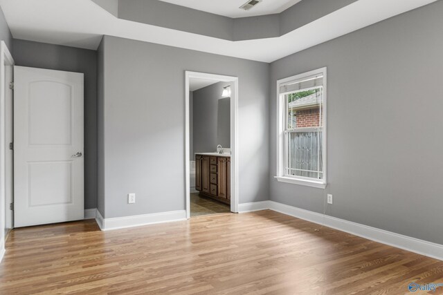 29929 Park Hill Dr, Madison, AL 35757 - unfurnished bedroom featuring light wood finished floors, baseboards, a sink, and ensuite bathroom