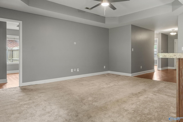 29929 Park Hill Dr, Madison, AL 35757 - carpeted spare room featuring a tray ceiling, a ceiling fan, and baseboards