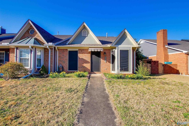 view of front of home with brick siding and a front lawn