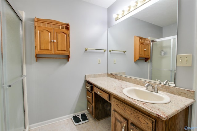 bathroom featuring vanity, a shower stall, baseboards, and tile patterned floors