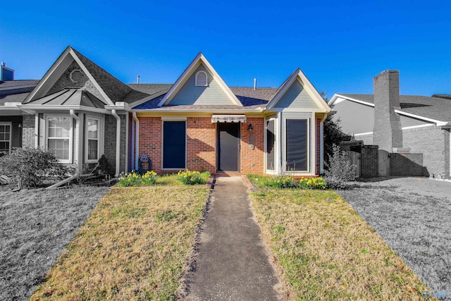 view of front of home featuring a front yard, a gate, and brick siding