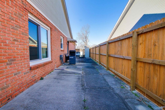 exterior space featuring a patio area, fence, and brick siding