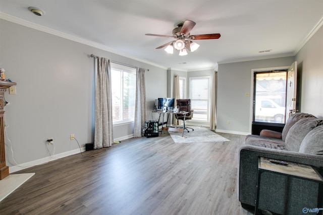 living room featuring baseboards, wood finished floors, a ceiling fan, and crown molding