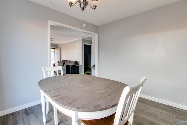 dining area featuring baseboards, a notable chandelier, wood finished floors, and crown molding