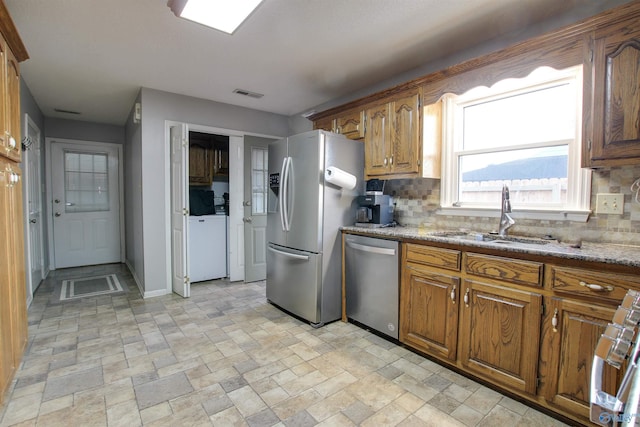 kitchen with a sink, stainless steel appliances, backsplash, and visible vents