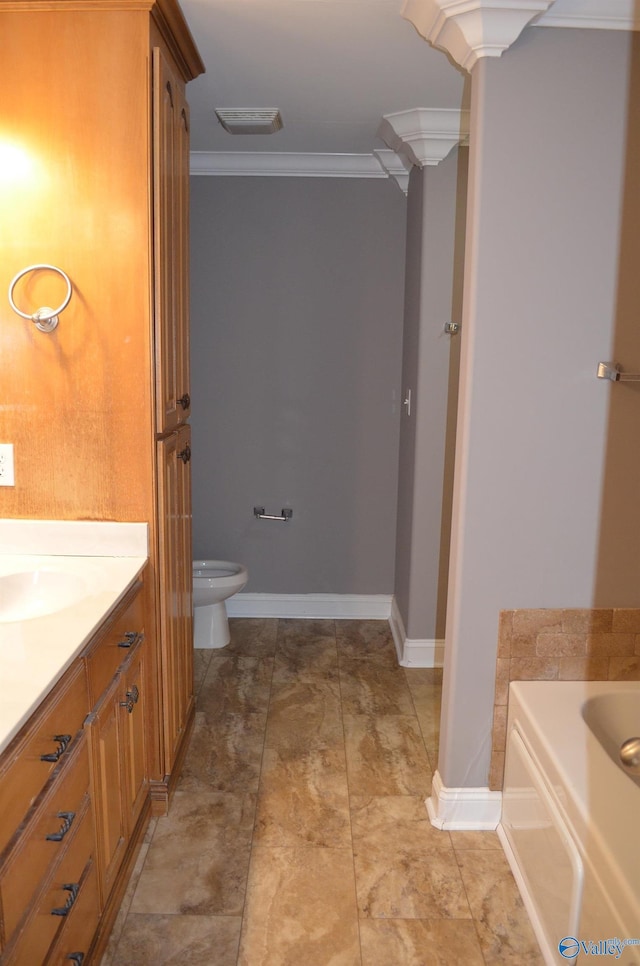 bathroom featuring crown molding, toilet, a garden tub, baseboards, and vanity