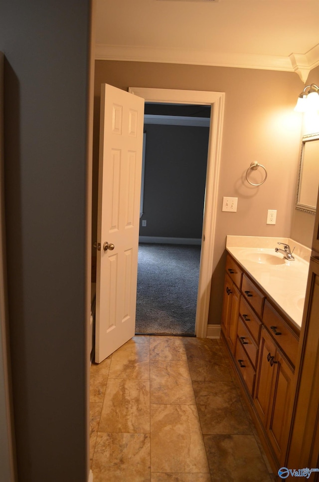 bathroom with ornamental molding, vanity, and baseboards