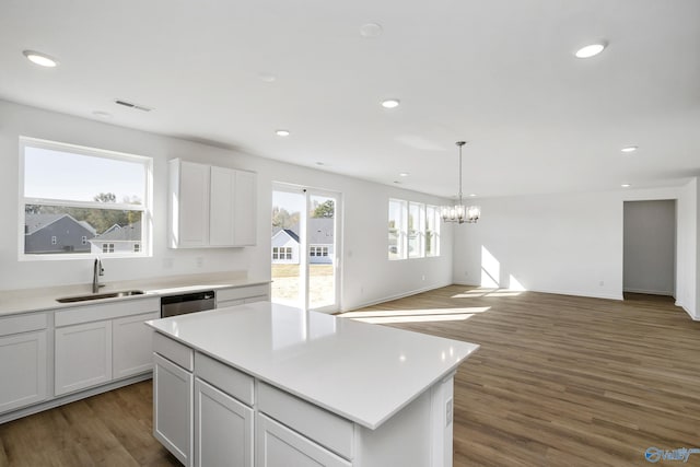 kitchen featuring white cabinetry, a center island, sink, and stainless steel dishwasher