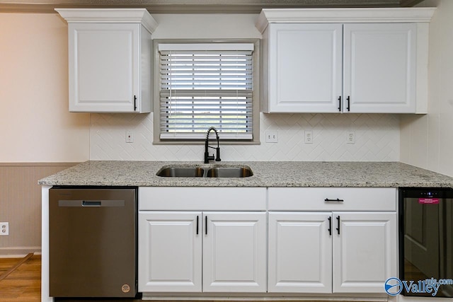 kitchen featuring stainless steel dishwasher, white cabinets, a sink, light stone countertops, and beverage cooler