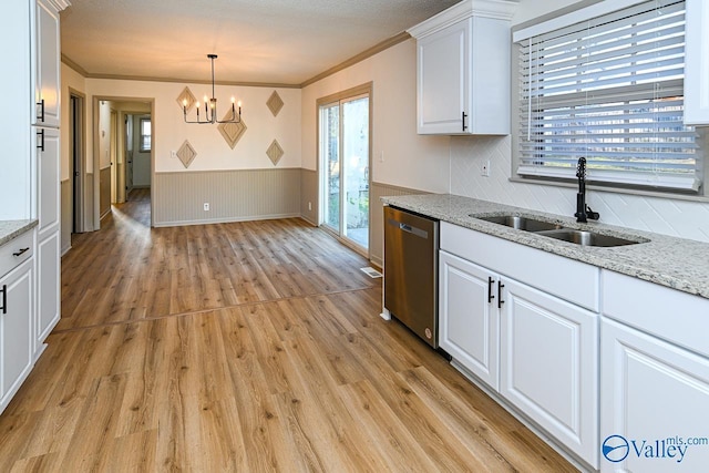 kitchen featuring dishwasher, wainscoting, light wood-style flooring, white cabinetry, and a sink