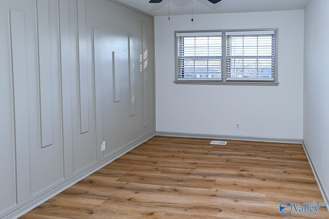 interior space with a ceiling fan, baseboards, visible vents, and wood finished floors