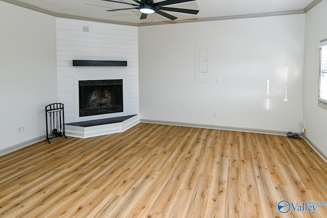 unfurnished living room featuring ornamental molding, a fireplace, ceiling fan, and wood finished floors