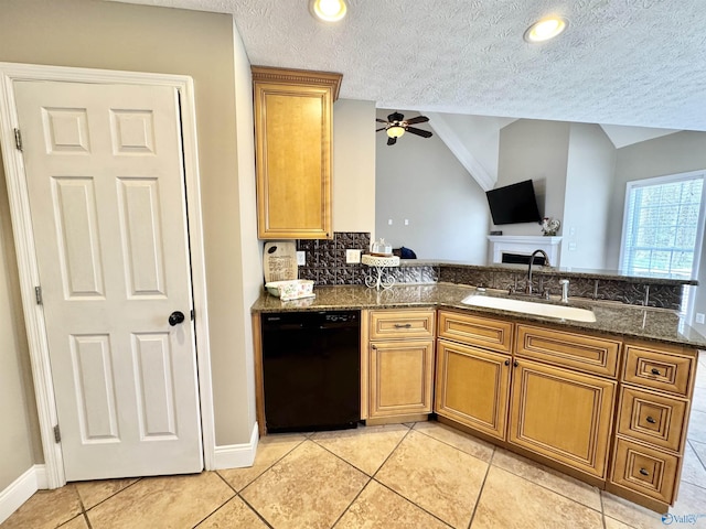 kitchen with a sink, a ceiling fan, dishwasher, brown cabinets, and dark stone counters
