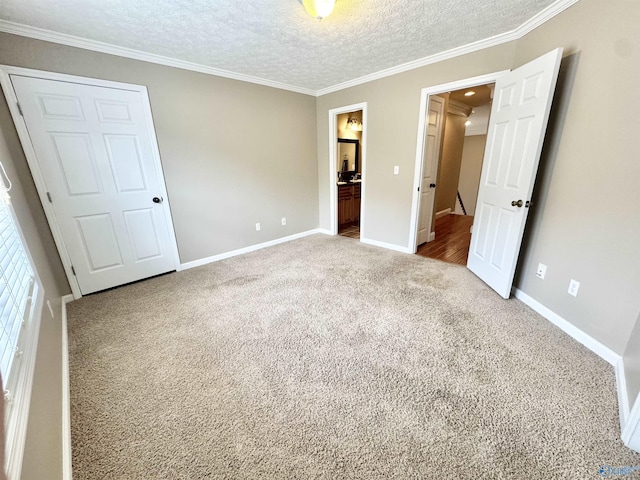 unfurnished bedroom with baseboards, ornamental molding, carpet, and a textured ceiling