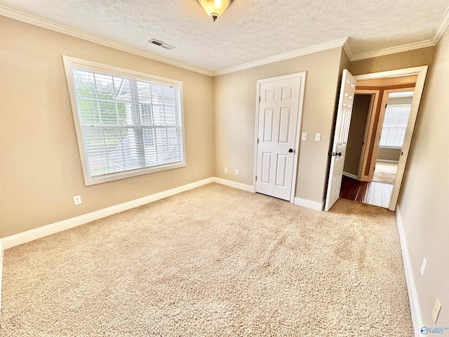 unfurnished bedroom with carpet flooring, ornamental molding, baseboards, and multiple windows