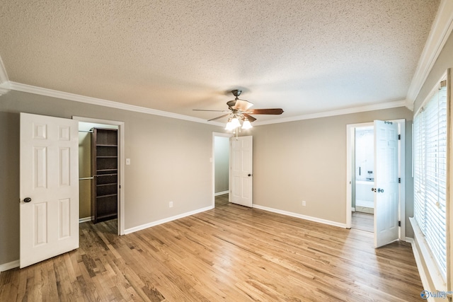2600 Gawain Rd SE, Huntsville, AL 35803 - unfurnished bedroom featuring a textured ceiling, light wood finished floors, crown molding, a walk in closet, and a closet
