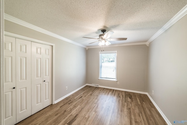 2600 Gawain Rd SE, Huntsville, AL 35803 - unfurnished bedroom with wood finished floors, a closet, crown molding, a textured ceiling, and a ceiling fan
