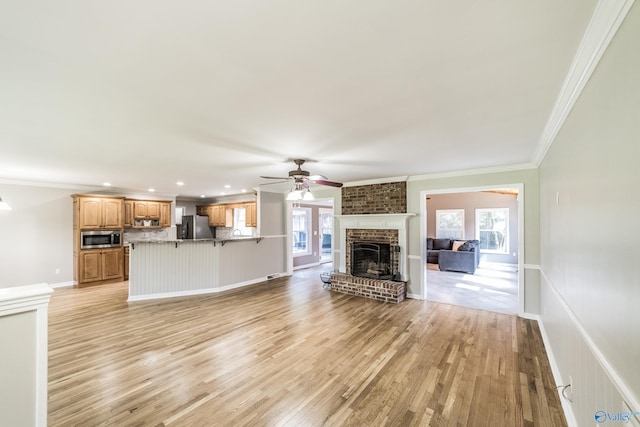2600 Gawain Rd SE, Huntsville, AL 35803 - unfurnished living room featuring a ceiling fan, a fireplace, light wood-style floors, crown molding, and recessed lighting