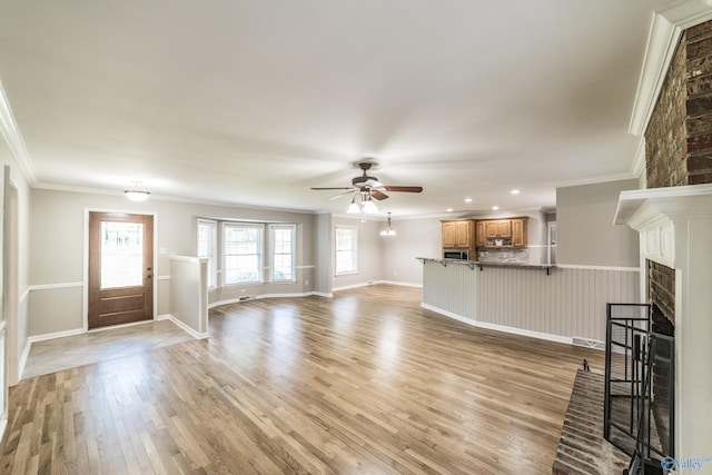 2600 Gawain Rd SE, Huntsville, AL 35803 - unfurnished living room with a ceiling fan, a fireplace, light wood-style floors, crown molding, and recessed lighting