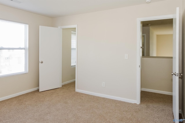 interior space featuring multiple windows and light carpet