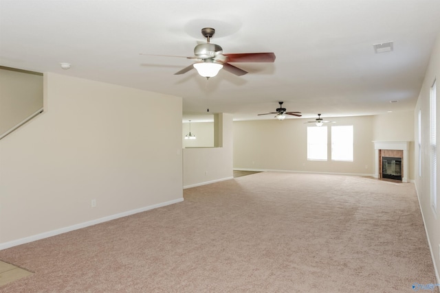 unfurnished living room featuring light carpet, ceiling fan, and a tile fireplace