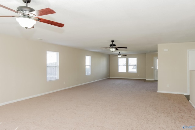 carpeted spare room with a healthy amount of sunlight and ceiling fan