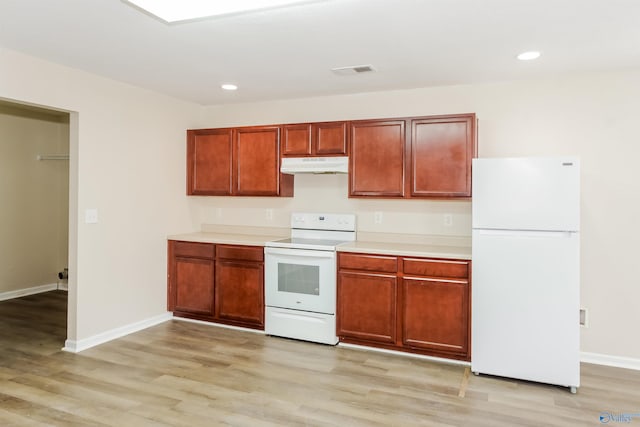 kitchen with light hardwood / wood-style flooring and white appliances