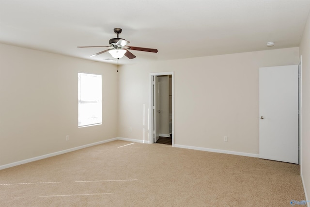 carpeted spare room featuring ceiling fan