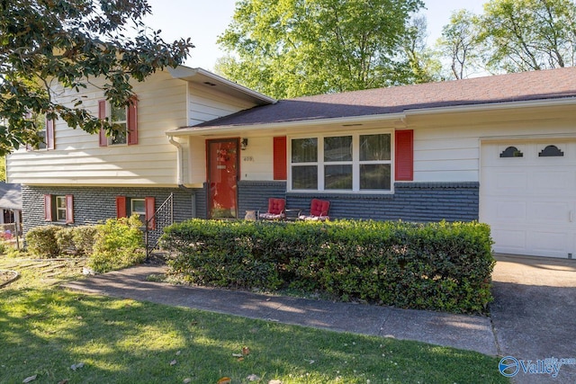 tri-level home with a garage and brick siding