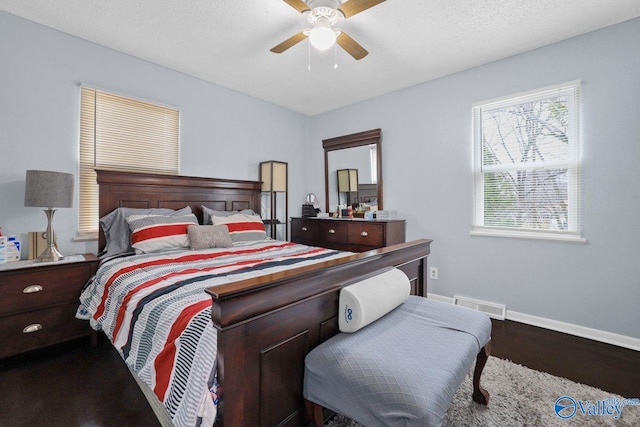 bedroom with visible vents, baseboards, a ceiling fan, a textured ceiling, and wood finished floors