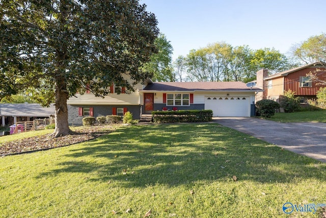 tri-level home with a garage, aphalt driveway, brick siding, and a front yard